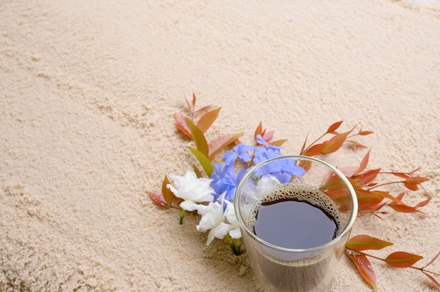 Вид сверху чашка кофе и цветок на пляже