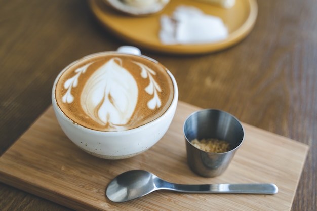 Top view a cup of coffee latte art in coffee shop cafe on wood board