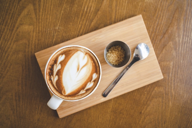 Top view a cup of coffee latte art in coffee shop cafe on wood board