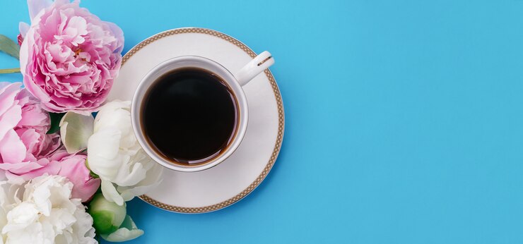 一杯のコーヒーと牡丹の花のトップビュー