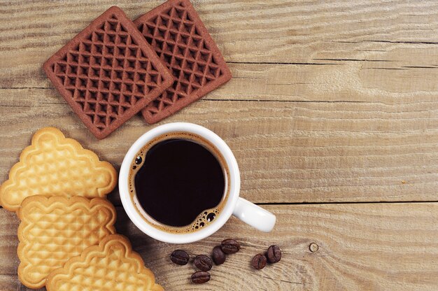 Top view on cup of coffee with creamy and chocolate cookies