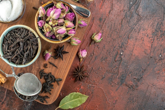 Top view cup of tea with black tea and dried flowers on dark brown background tea fruit water color breakfast drink ceremony photos