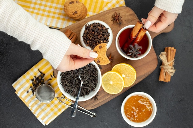 暗い背景の朝のコーヒーの色のテーブルの卵の家族の食事に紅茶の蜂蜜とレモンのスライスとお茶のトップビューカップ