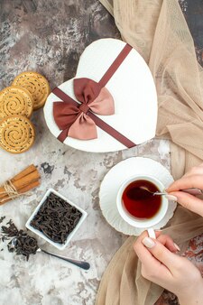 Vista dall'alto tazza di tè con biscotti dolci e presente su sfondo chiaro san valentino coppia sensazione colore amore matrimonio biscotto zucchero