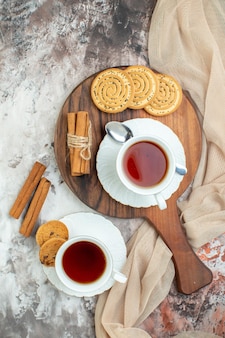 Vista dall'alto tazze di tè con biscotti dolci e biscotti sullo sfondo chiaro pausa torta di zucchero cerimonia torta color caffè
