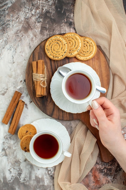 Top view cups of tea with sweet biscuits on a light background color ceremony pie coffee sugar break