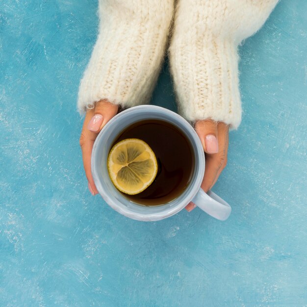 Top view cute winter tea being held by woman's hands