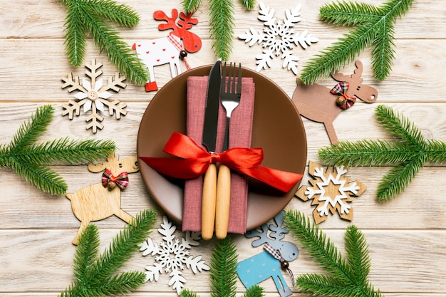 Top view of cutlery and plate on festive wooden surface. 