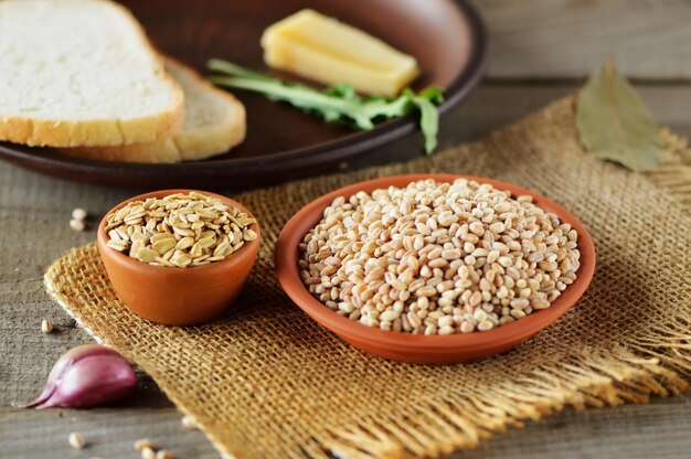 Top view On a dark backgroundwheat bread slicesBowls with wheat grains
