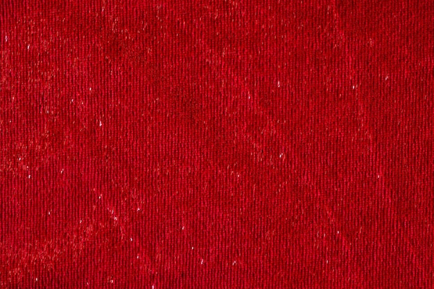 Top view of dark red smooth textile material with shiny thread textured background natural