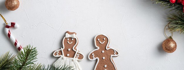 Top view of decorated Christmas gingerbread cookies with decorations on white table background with copy space, concept of holiday celebration.
