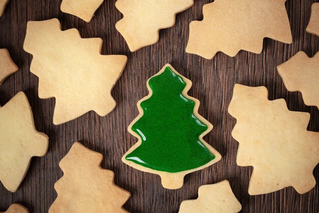 Photo top view of decorated christmas tree sugar cookie on wooden table background