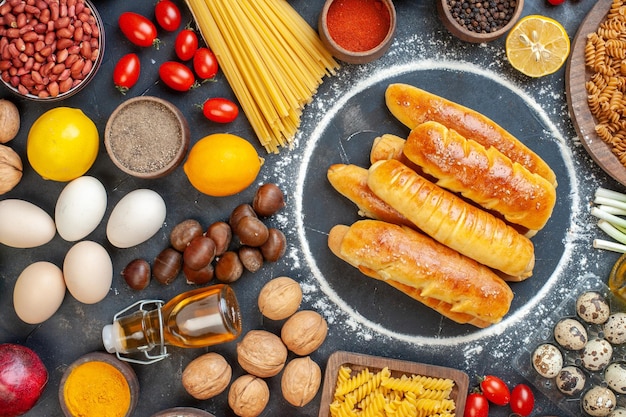 Top view delicious bagels with nuts eggs pasta and seasonings on the dark background walnut meal pepper fruit photo color food