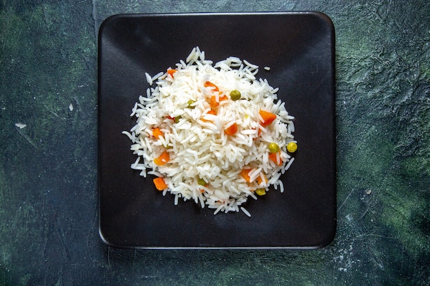 Photo top view delicious boiled rice with beans inside plate on dark desk