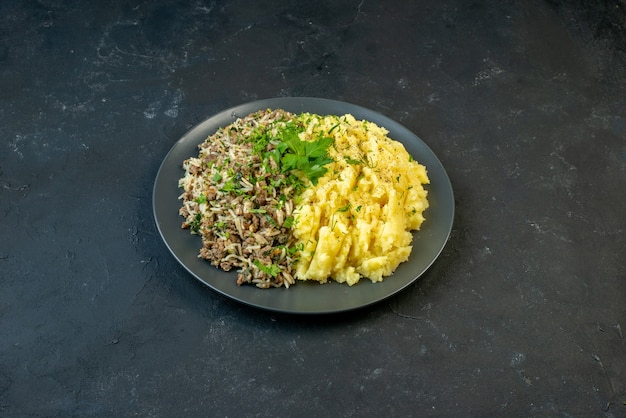 Top view of delicious dinner with mashed potatoes and meat on a plate on black background with free space