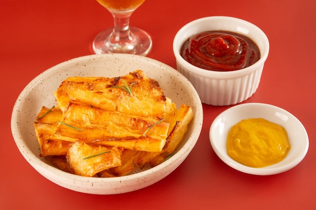 Top view Delicious Fried Cassava in Handcrafted White Ceramic Bowl on Red Studio Background