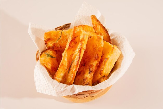 Top view Delicious Fried Cassava in Handcrafted wooden Bowl on white Studio Background