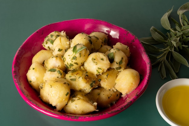 Top view Delicious Fried Gnocci with sage butter in a pink bowl and a red blackground