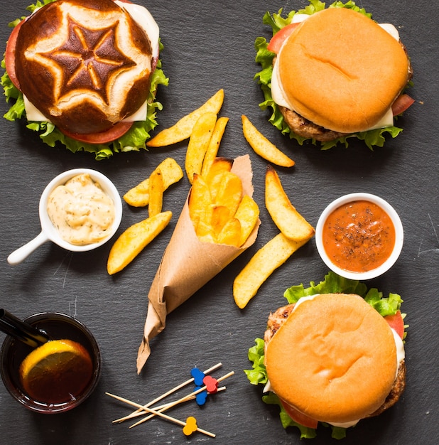 Photo top view of delicious hamburger, with vegetables,  on a wooden background.