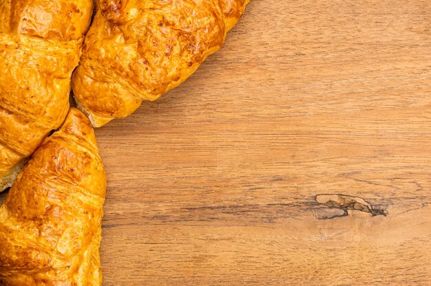 Top view of delicious homemade croissants on wooden board with copy space