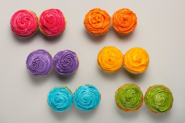 Foto vista dall'alto deliziosa glassa per cupcake arcobaleno ancora in vita