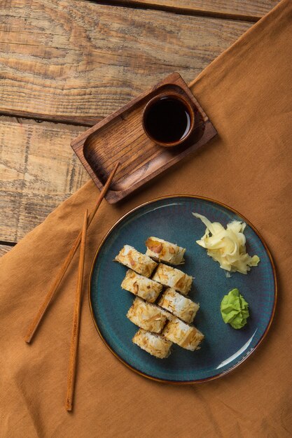 Top view of delicious sushi rolls with ingredients on wooden table