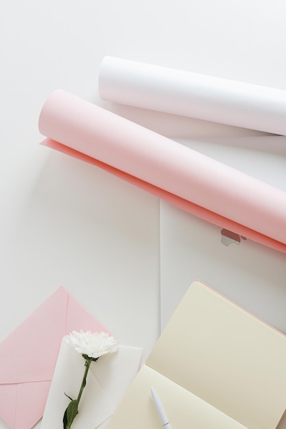 Top view of a desk with stationery flowers and laptop