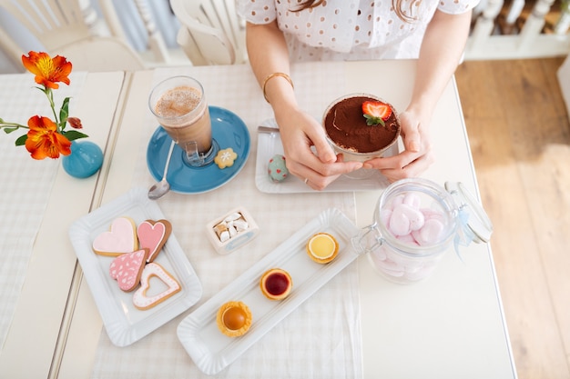 Top view of dessert, cakes, heart shaped cookies and latte on the table in cafe