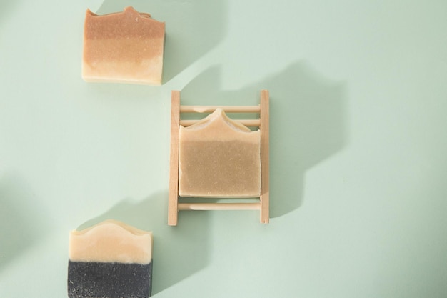 Top view of different handmade soap bars on mint background