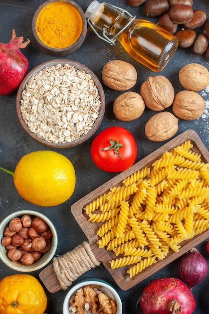 Foto vista dall'alto diversi ingredienti uova noci verdure pasta e condimenti su sfondo scuro pasto zucchero torta foto colore dieta pasta cruda