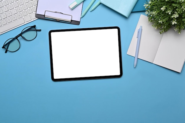 Top view Digital tablet with empty display, glasses and notebooks on lea background.