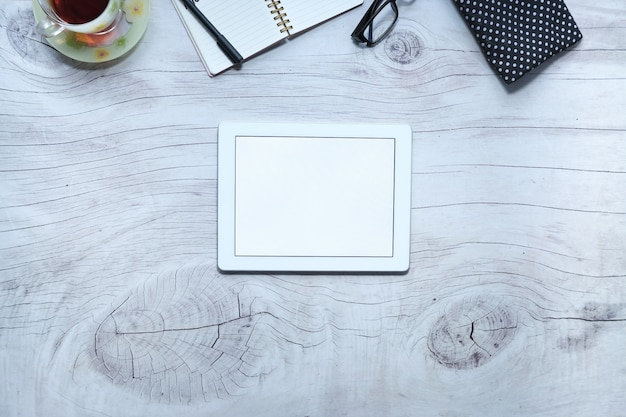 Top view of digital tablet with office suppliers on table