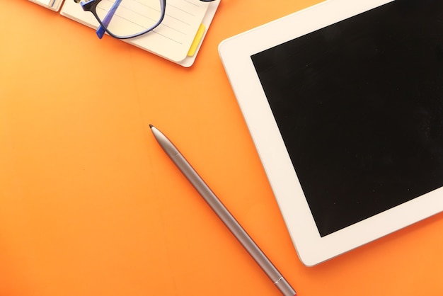 Top view of digital tablet with office suppliers on table