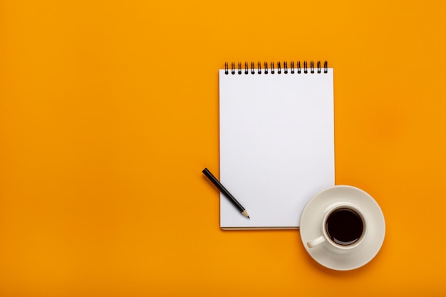 Top view of doctor desk table with stethoscope, coffee and blank paper on clipboard with pen.