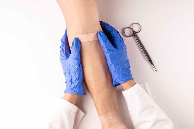 Top view of a doctor healing a injury with a tape or plaster.