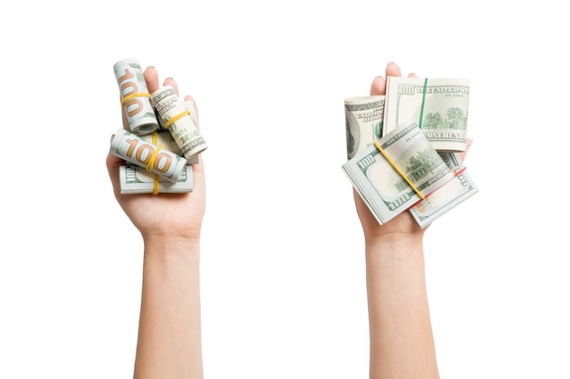 Top view of dollar bills in tubes in female hands on white isolated surface