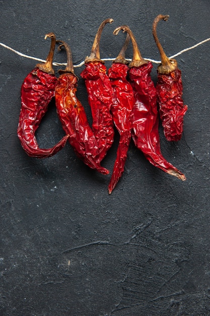 Top view of dried hot red peppers on black background with free space