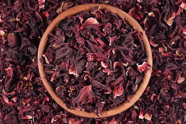 Top view of dried petals of hibiscus in a wooden bowl