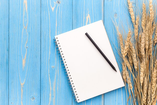 Top view of dried wheat crop on blue wooden board