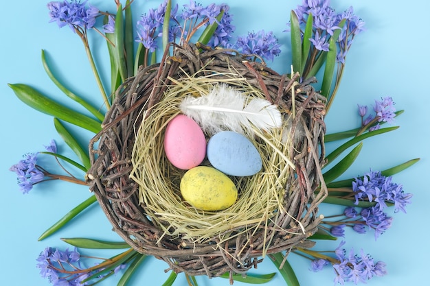 Top view of easter egg nest and snowdrops flat lay