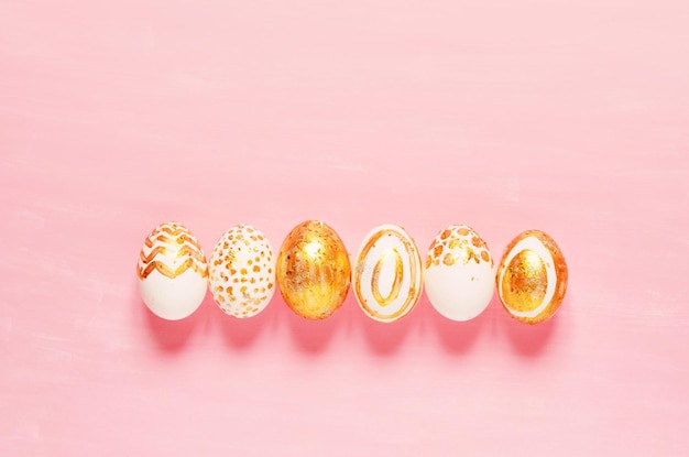 Top view of easter eggs colored with golden paint in differen patterns. Copy space. - Image