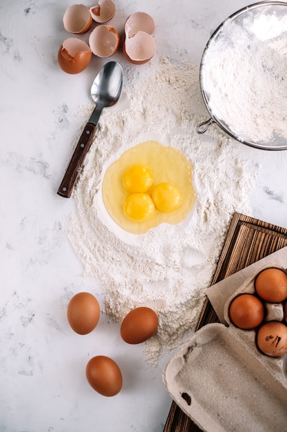 Top view eggs in flour on the kitchen table