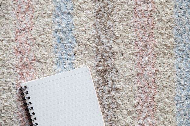 Top view of empty notepad on tablecloth, copy space