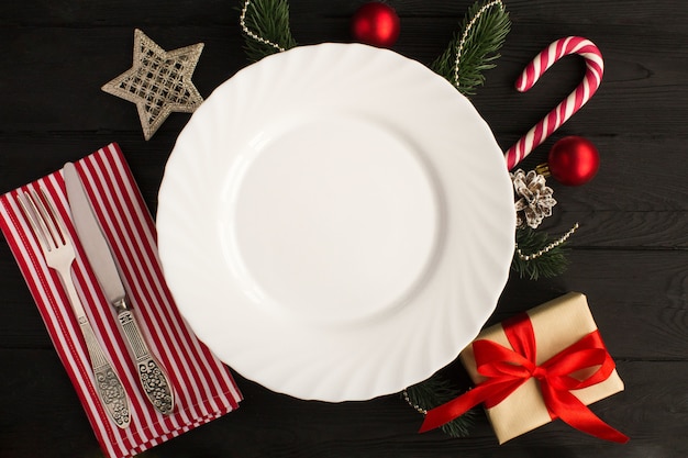 Вид сверху пустой тарелки и рождественской композиции на черном