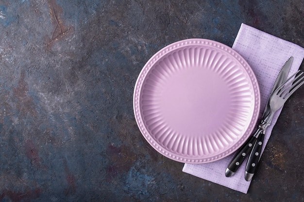 Top view of empty plate with napkin, knife and fork.