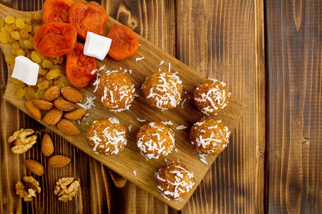 Top view of energy balls with dried apricots and ingredients on the cutting board