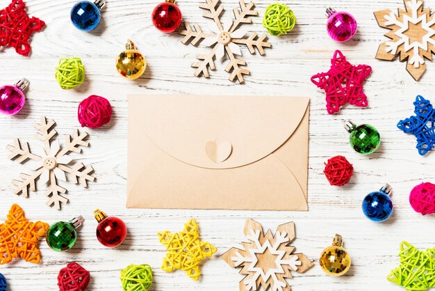 Photo top view of envelope on festive wooden background christmas toys and decorations new year time concept