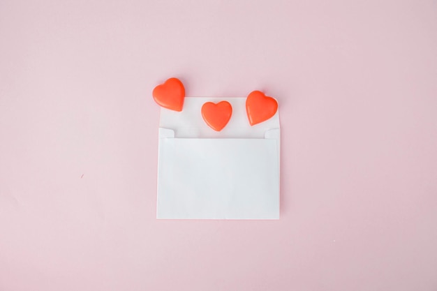 Top view of an envelope and orange love candies