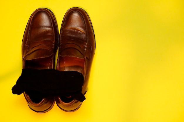 Top view of executive shoes on a blue yellow background with space to write. flat lay