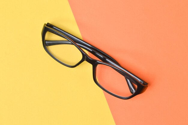 Top view of eyeglasses isolated on yellow and orange background